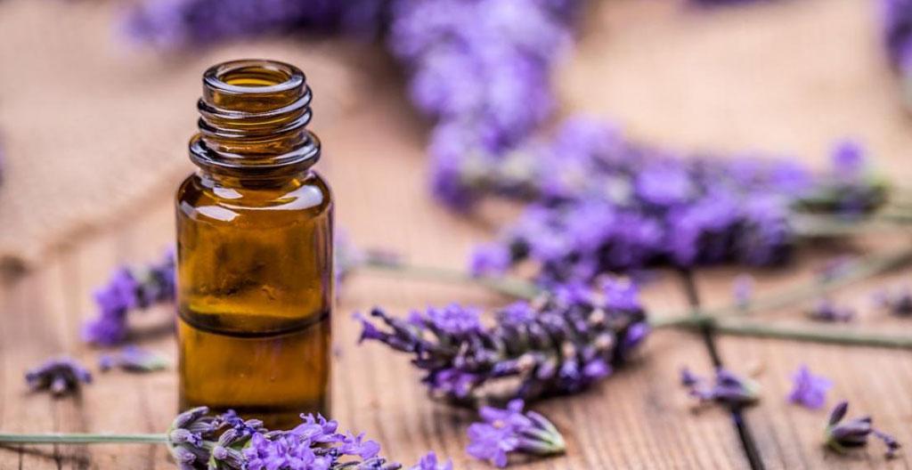 Balance de précision ancienne en équilibre avec flacon d'huile essentielle et gouttes d'un côté, lavande séchée de l'autre